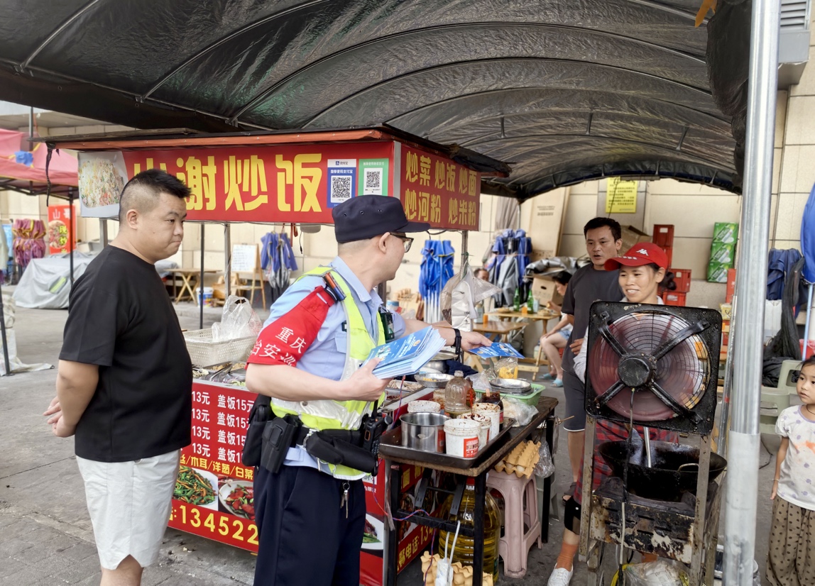 6月26日傍晚,民警冉启诚在夜市开展反诈宣传3